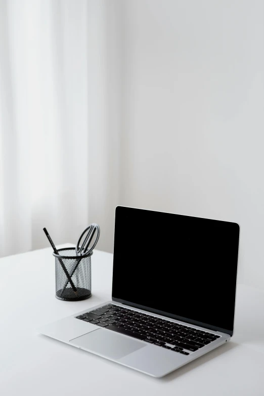 a laptop computer sitting on top of a white table, by Andries Stock, pexels, minimalism, black, with a straw, in a white room, black theme