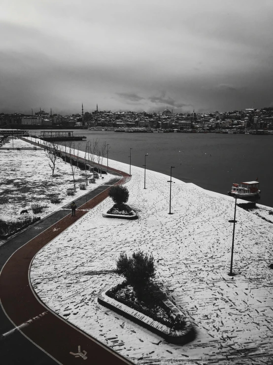 a black and white photo of a snow covered road, by Yasar Vurdem, happening, the sea seen behind the city, red and white color theme, detailed medium format photo, 🚿🗝📝