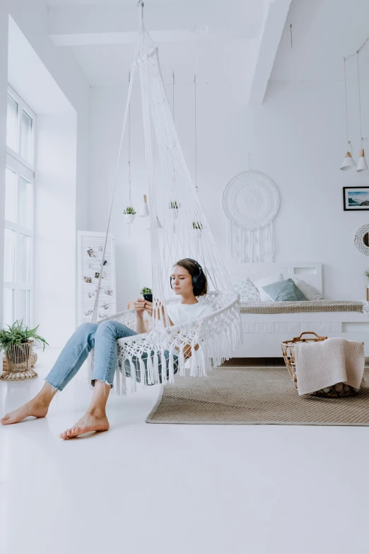 a woman sitting in a hammock in a white room, pexels contest winner, teenager hangout spot, high-quality render, promo image, apartment design