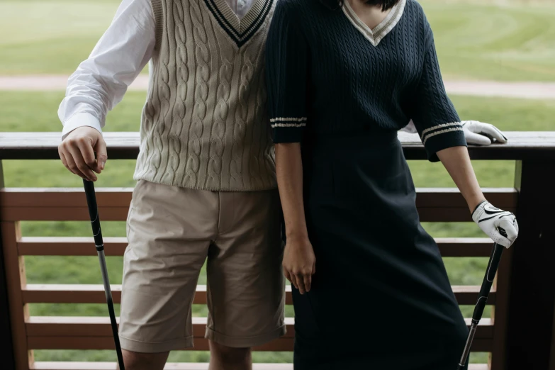 a man and a woman standing next to each other, a colorized photo, unsplash, wearing golf shorts, costumes from peaky blinders, gemma chen, catalog photo