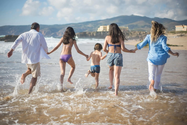 a family running in the water at the beach, pexels contest winner, renaissance, portugal, thumbnail, back towards camera, casually dressed