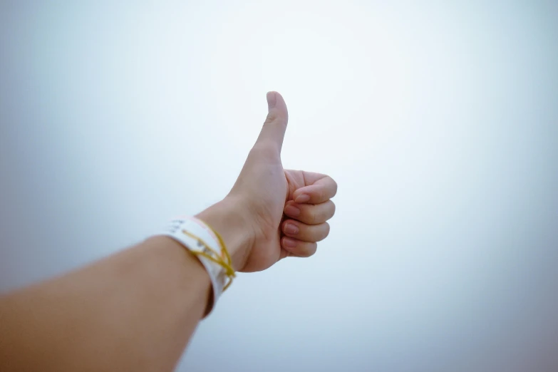 a close up of a person's hand giving a thumbs up, pexels contest winner, waist high, rating:g, white backround, background image