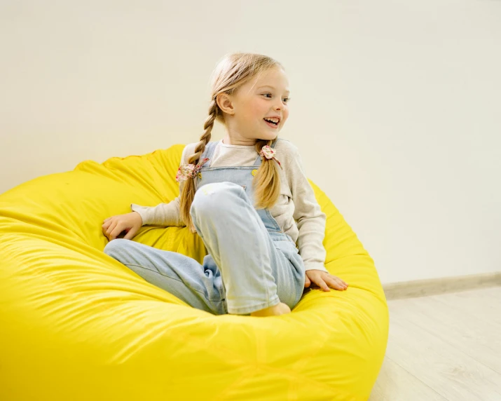 a little girl sitting on a bean bag chair, inspired by Sarah Lucas, pexels contest winner, light yellow, medium height, thumbnail, round
