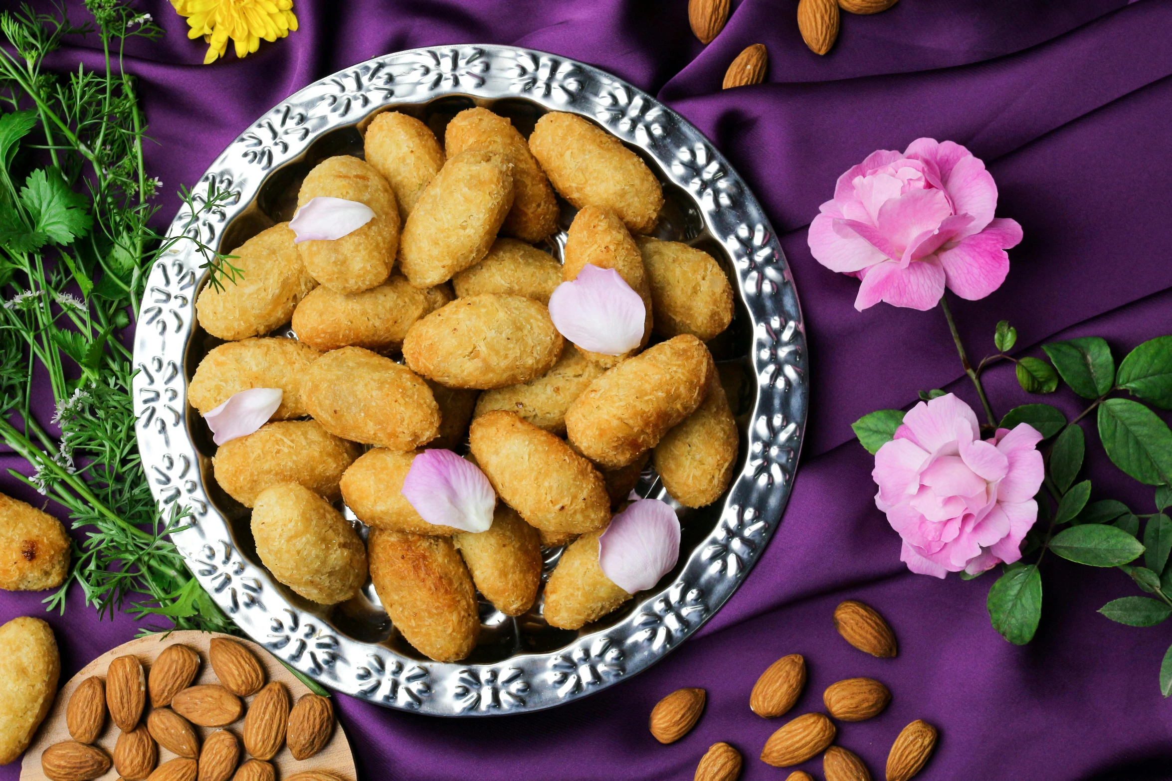 a bowl filled with nuts and flowers on top of a purple cloth, hurufiyya, chicken nuggets, background image, festivals, silver platter