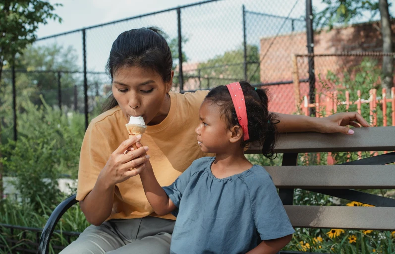 a woman sitting on a bench next to a little girl eating an ice cream cone, pexels contest winner, asian descent, thumbnail, high quality photo, animation still