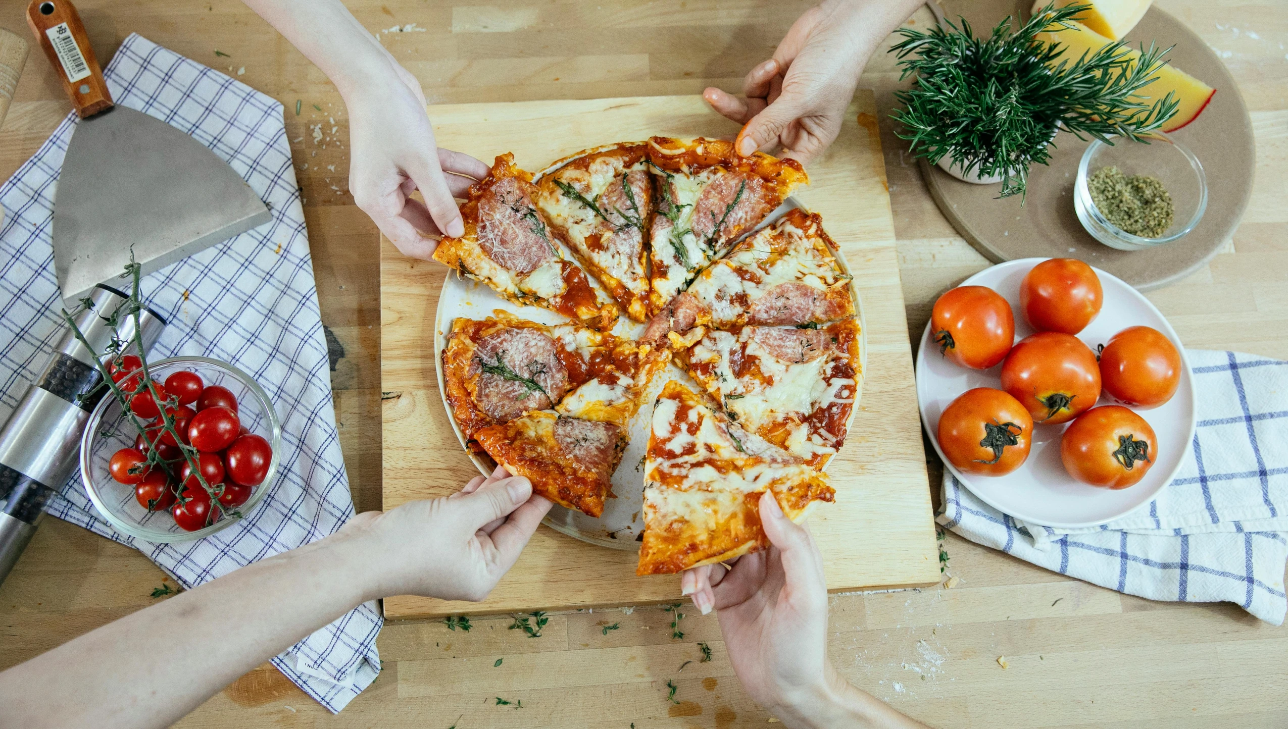 a couple of people cutting a pizza on a cutting board, by Julia Pishtar, fan favorite, a high angle shot, item, four hands