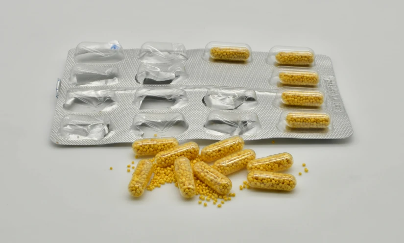 a packet of corn sitting on top of a table, pills, detailed product image, 8 intricate golden tenticles, high quality product image”