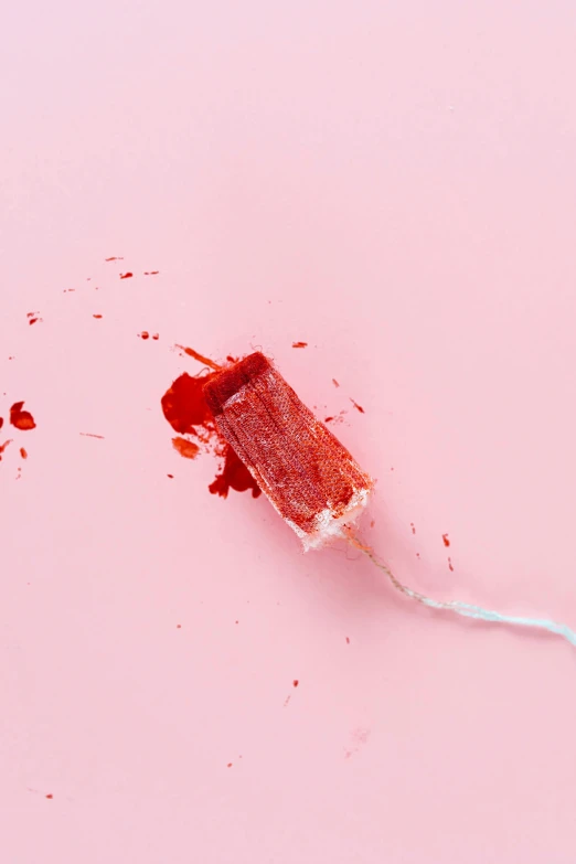 a red toothbrush sitting on top of a pink surface, by Elsa Bleda, conceptual art, covered in blood, lollipop, ilustration, journalism photo