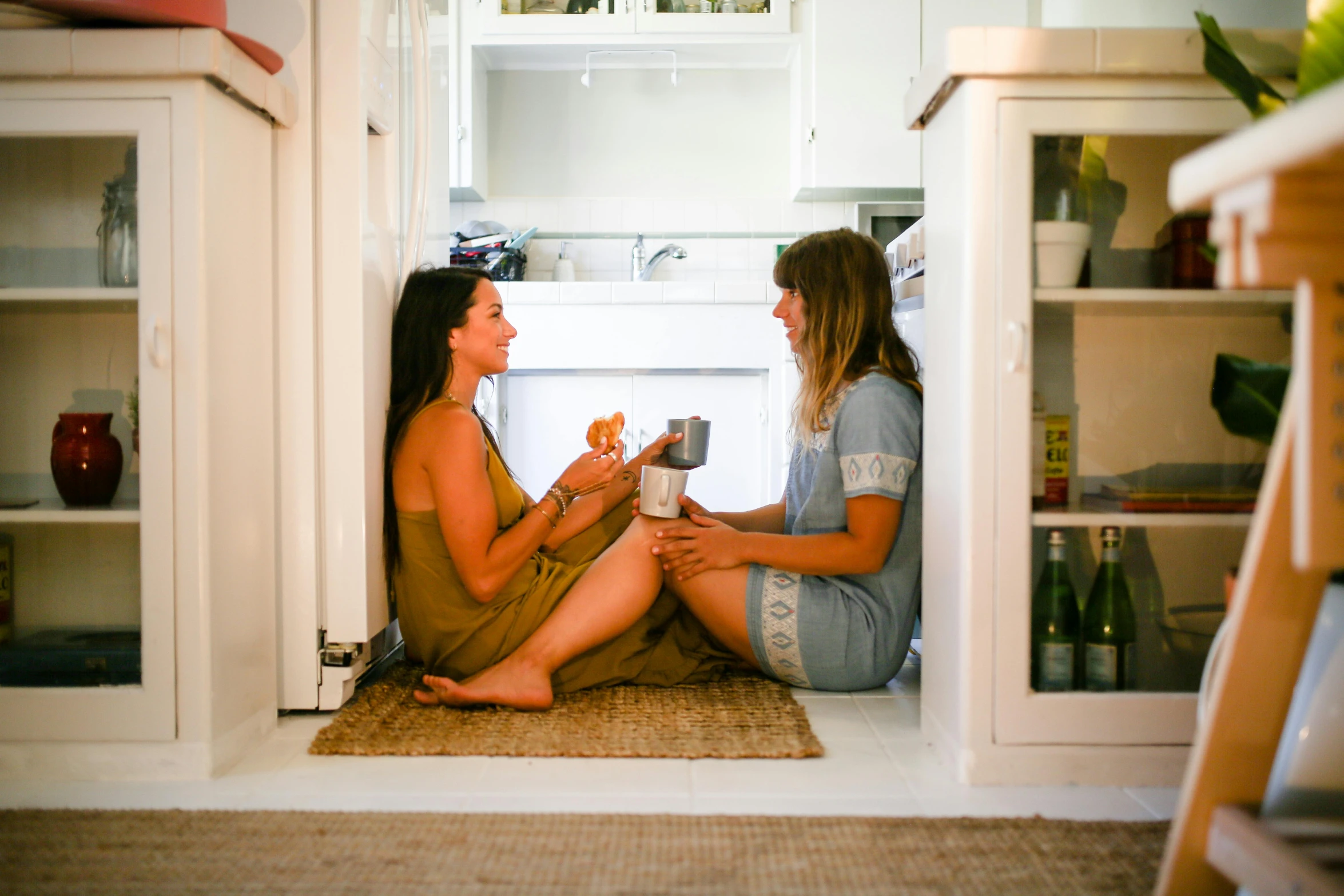 two women sitting on the floor in a kitchen, by Jessie Algie, pexels contest winner, fridge, toast, summer setting, white