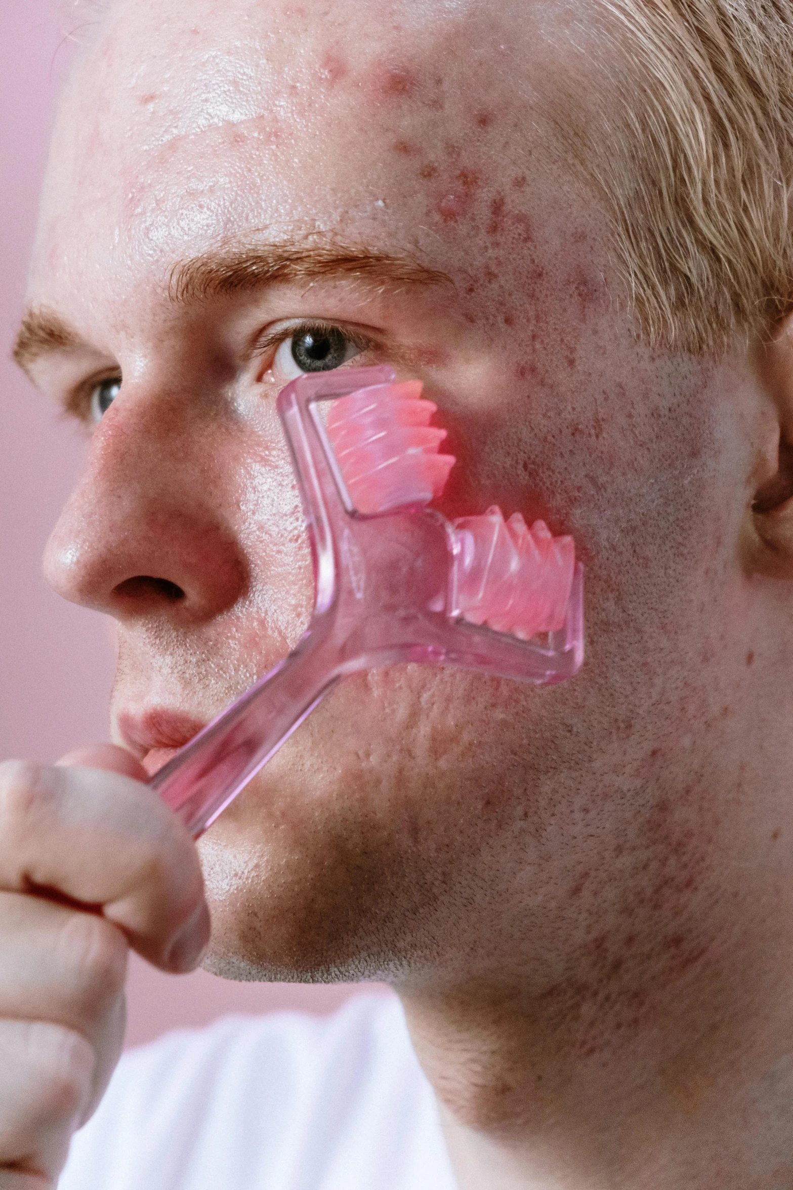 a man brushing his teeth with a pink toothbrush, by Adam Marczyński, reddit, trypophobia acne face, translucent gills, model, square jaw