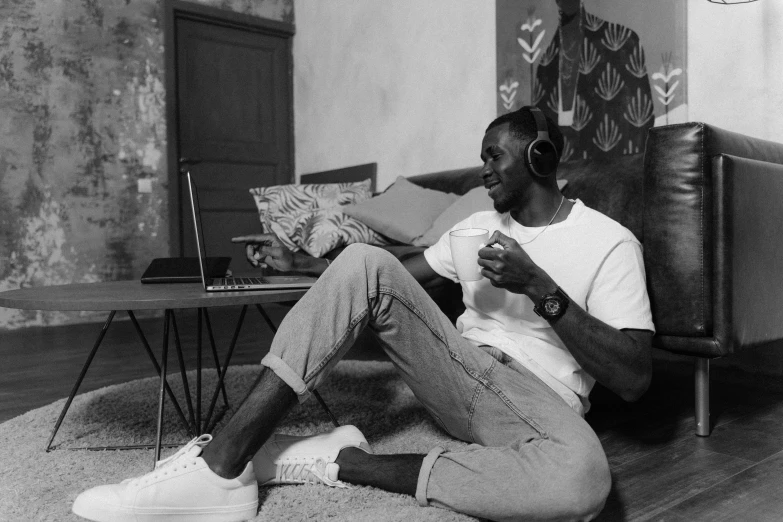 a black and white photo of a man sitting on the floor, a black and white photo, pexels, figuration libre, he has headphones, black man, having a snack, 🌻🎹🎼