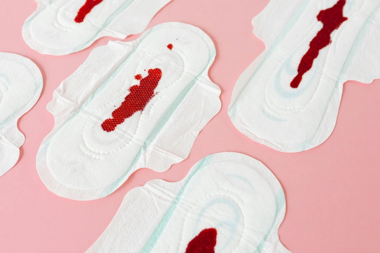 a bunch of sanitary pads sitting on top of a pink surface, inspired by Louise Bourgeois, blood dripping from eyes, silicone patch design, medium close up, spraying blood