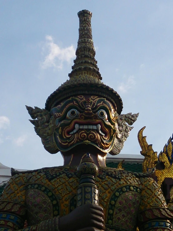 a close up of a statue in front of a building, in front of a temple