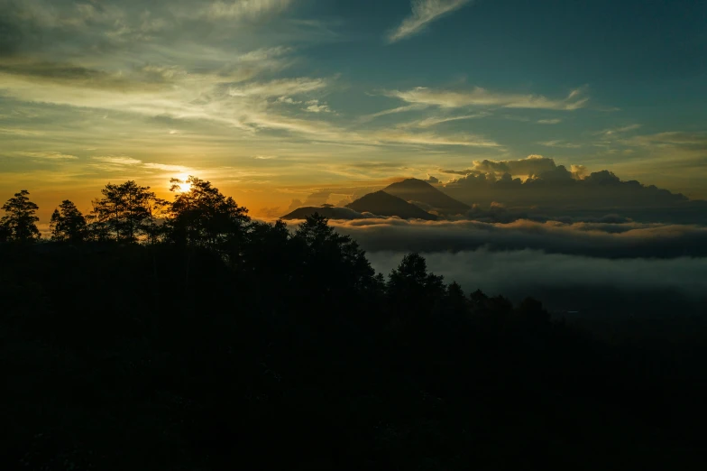 the sun is setting over the mountains above the clouds, pexels contest winner, sumatraism, over the tree tops, grey, overview, ((sunset))