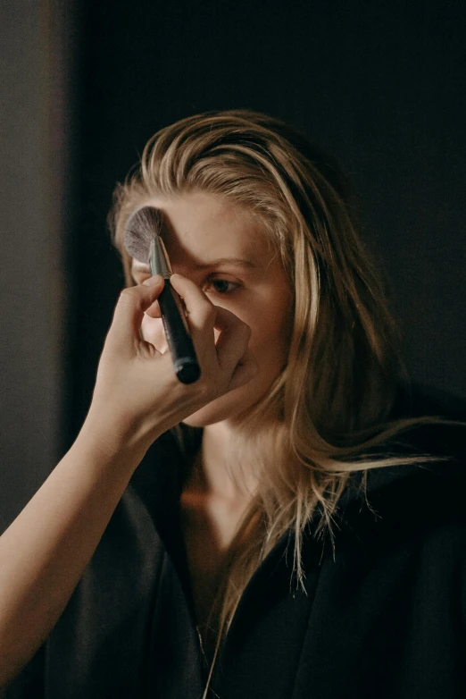 a woman brushing her hair in front of a mirror, black eye shadow, britt marling style 3/4, sculpting, foam