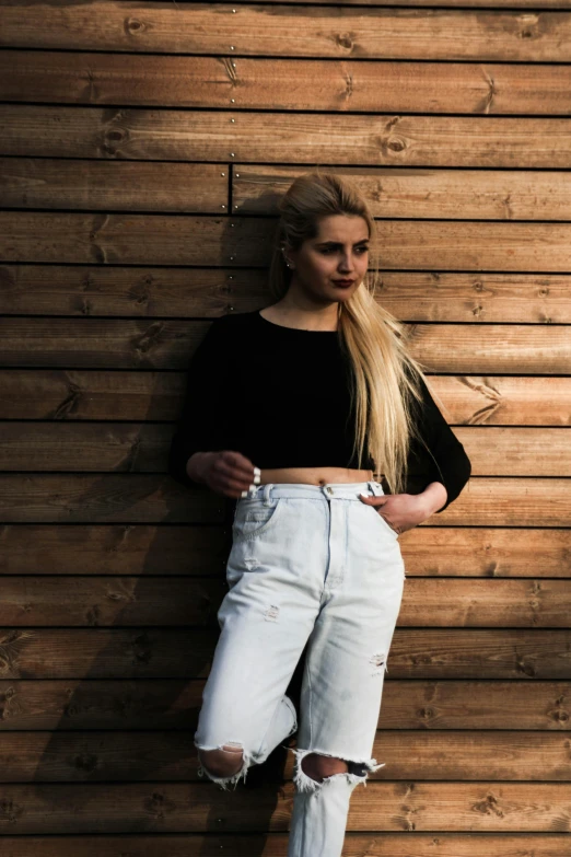 a woman leaning against a wooden wall, an album cover, inspired by Elsa Bleda, pexels contest winner, ( ( ( wearing jeans ) ) ), 15081959 21121991 01012000 4k, blonde swedish woman, round-cropped