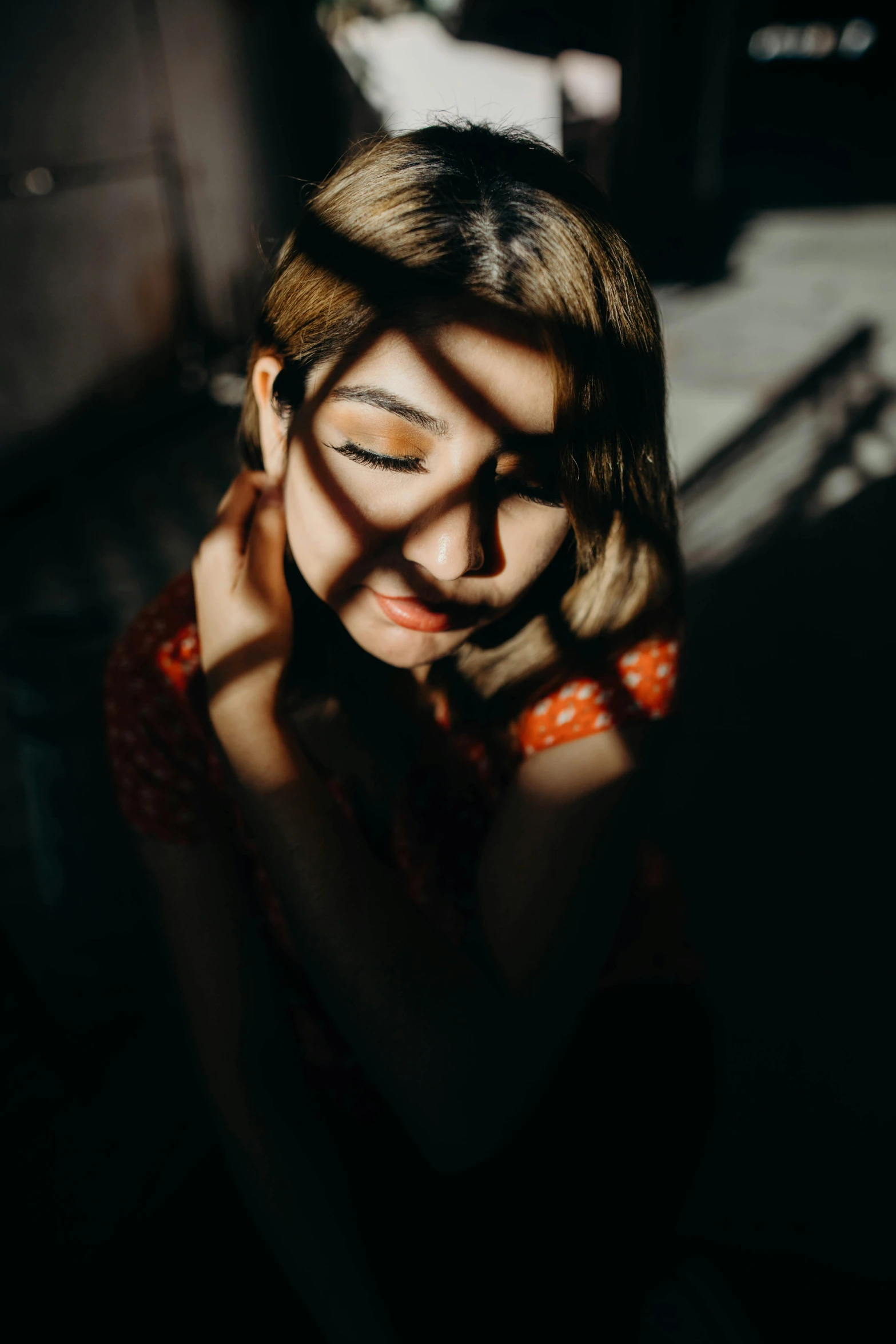 a woman sitting in the dark with her eyes closed, a picture, inspired by Elsa Bleda, trending on pexels, light and space, portrait casting long shadows, asian woman, high angle closeup portrait, instagram post