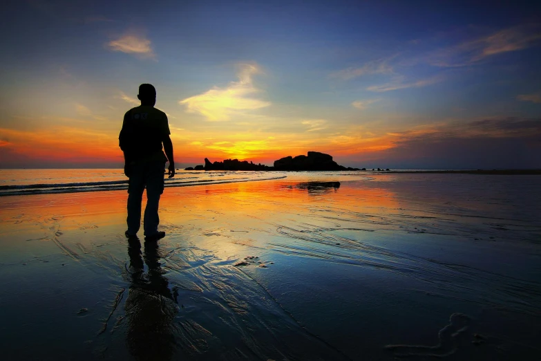 a man standing on top of a beach next to the ocean, during a sunset, walking on water, profile pic, multiple stories