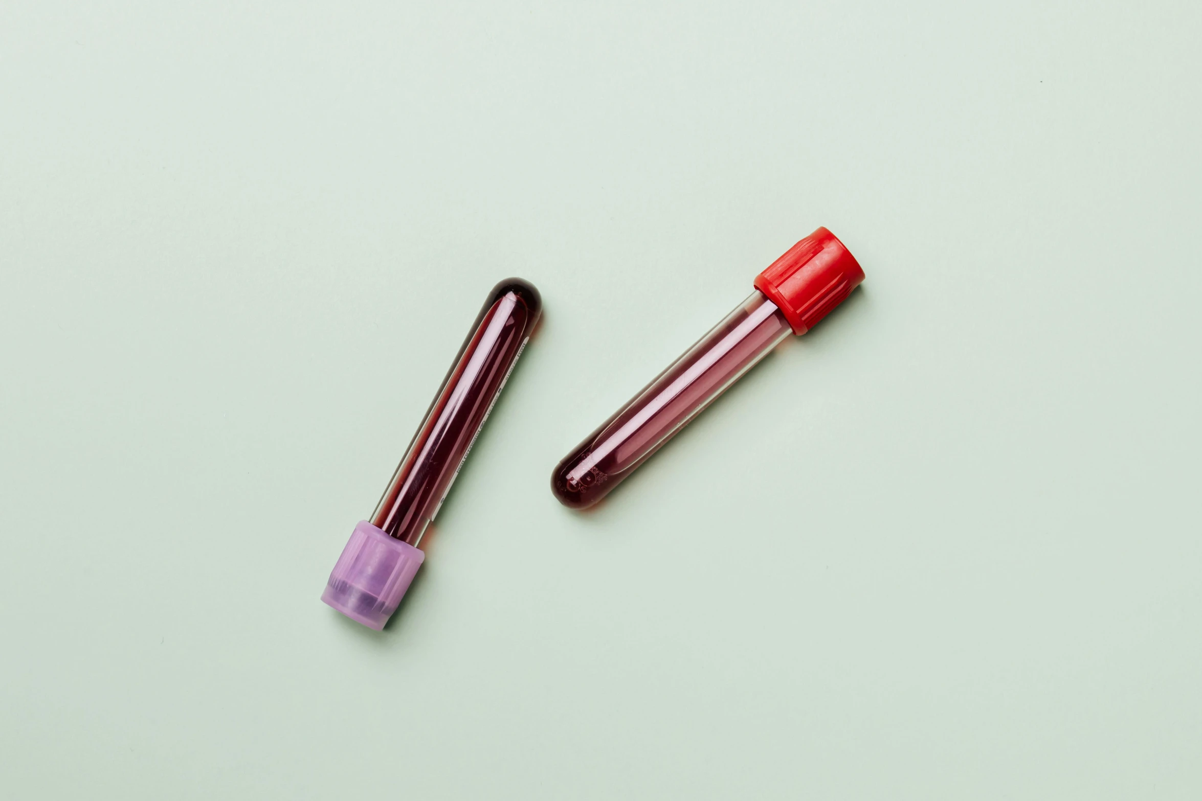 a tube of blood and a tube of blood on a green background, trending on pexels, purple tubes, on a pale background, highly capsuled, analogue