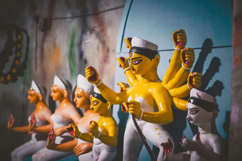 a group of figurines sitting on top of a wall, pexels contest winner, bengal school of art, religious imagery, 🕹️ 😎 🔫 🤖 🚬, bodypainting, shrines