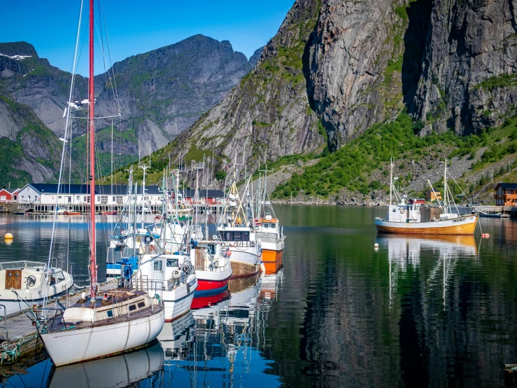 a number of boats in a body of water, a picture, inspired by Tove Jansson, pexels contest winner, hurufiyya, mountain, port, svend smital, thumbnail