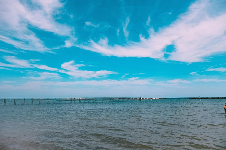 a couple of people that are standing in the water, by Carey Morris, pexels contest winner, panorama view of the sky, blue and cyan colors, from wheaton illinois, harbor