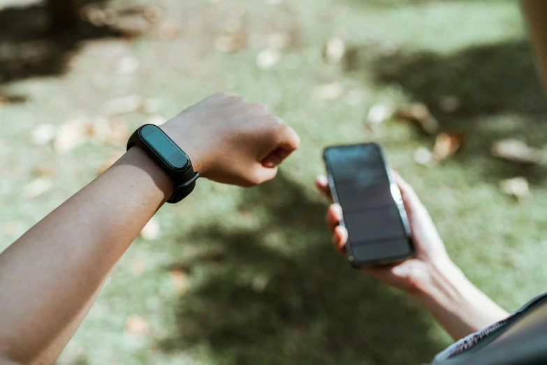 a close up of a person holding a cell phone, in a park, wearing a watch, tiny person watching, connectivity