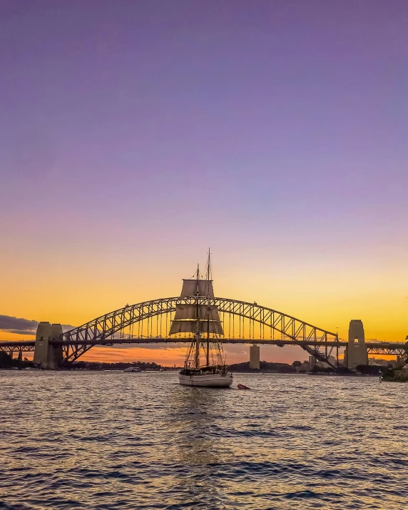 a large bridge over a body of water, inspired by Sydney Carline, pexels contest winner, happening, he's on an old sailing boat, lgbtq, twilight skyline, aboriginal