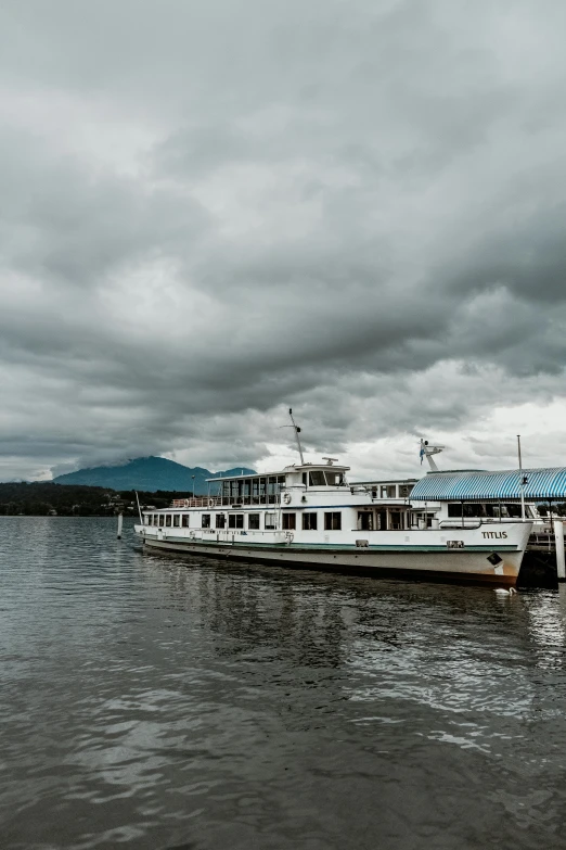 a boat that is sitting in the water, grey cloudy skies, in karuizawa, lachlan bailey, as photograph