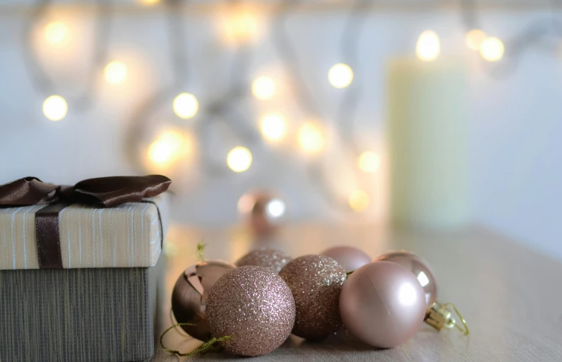 a gift box sitting on top of a wooden table, by Alice Mason, pexels contest winner, romanticism, soft pink lights, cyber copper spiral decorations, grey, chocolate