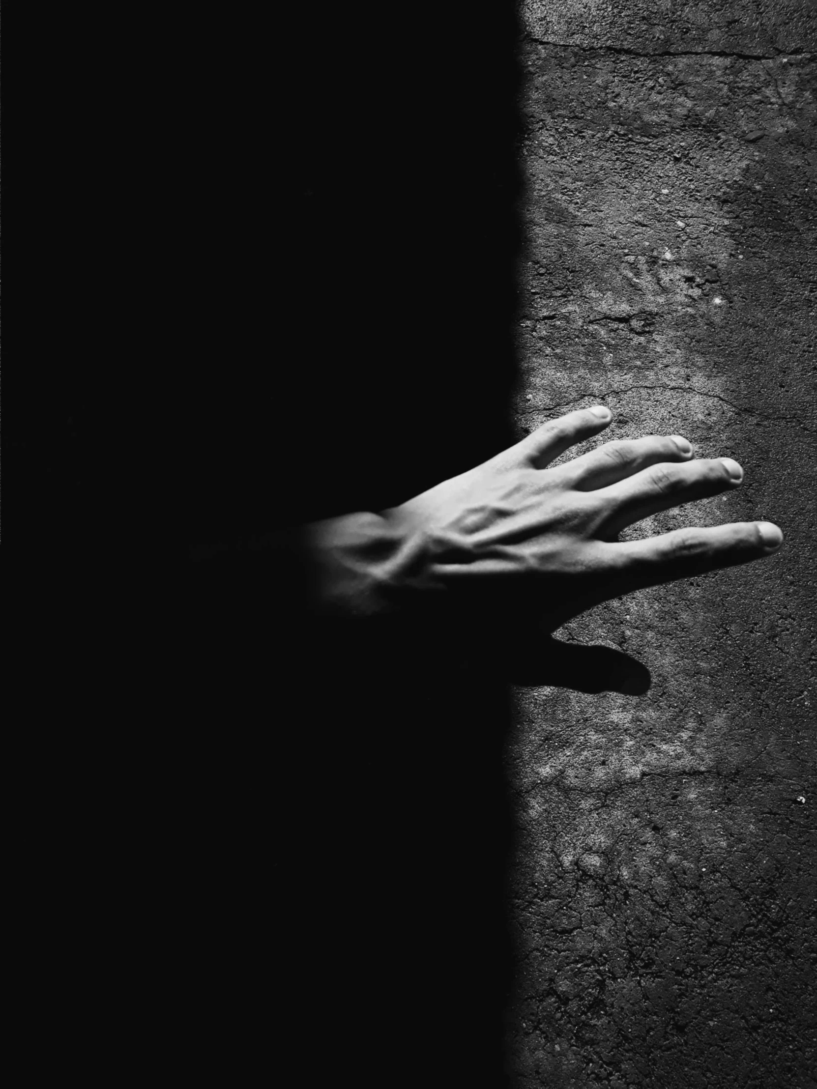 a black and white photo of a hand reaching out of a wall, by Raoul Ubac, unsplash, conceptual art, dark shadowy surroundings, ffffound, sunlight filtering through skin, ilustration