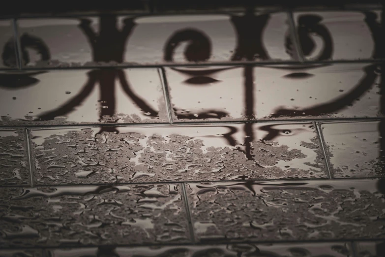 a black and white photo of a tiled floor, unsplash, graffiti, wet eye relections, sepia photography, carnal ) wet, drops