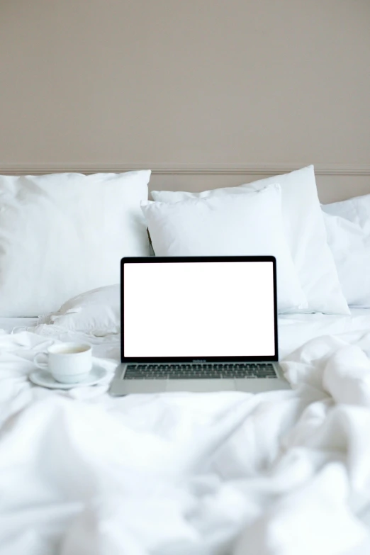 a laptop computer sitting on top of a bed, by Carey Morris, pexels, white pillows, rectangle, multiple stories, on a white table