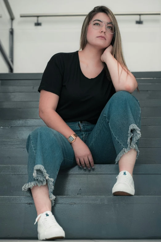 a woman sitting on a set of stairs, inspired by Jean Hey, trending on pexels, wearing pants and a t-shirt, rounded corners, black canvas, teal