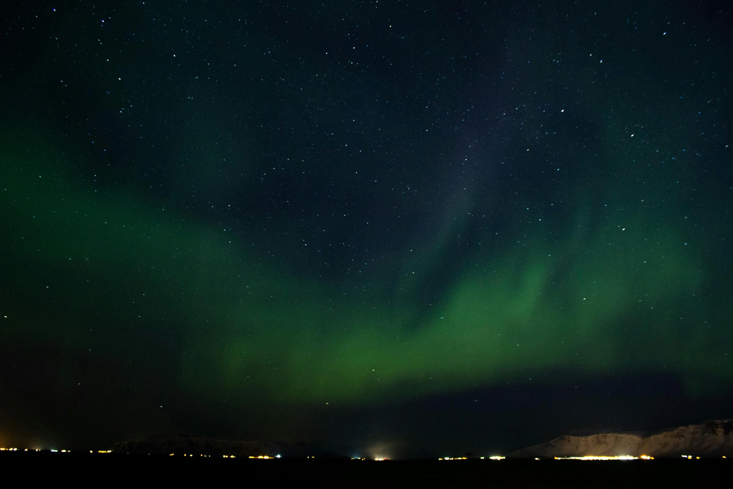 the aurora bore lights up the night sky, by Ejnar Nielsen, pexels contest winner, hurufiyya, city lights on the horizon, green lights, big sky, panoramic