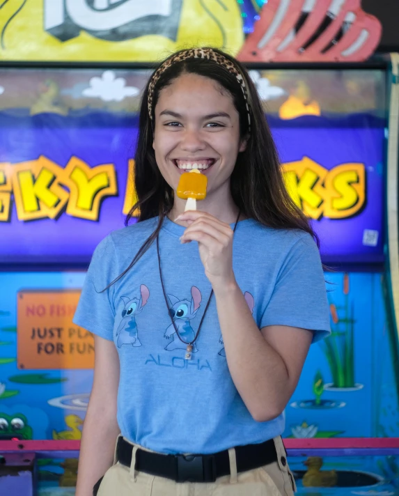 a girl holding a piece of food in front of a game machine, wearing a light blue shirt, sherbert sky, alex flores, platypus