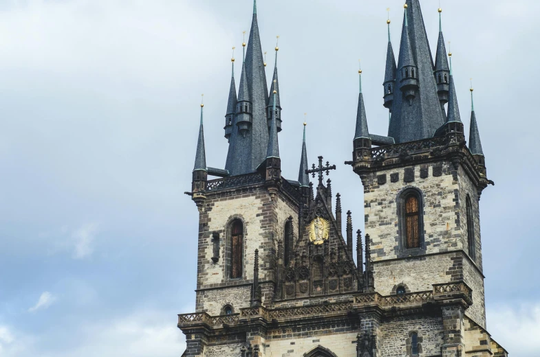 a large building with a clock on the front of it, by Matija Jama, pexels contest winner, art nouveau, tall stone spires, gothic castle, peaked wooden roofs, grey