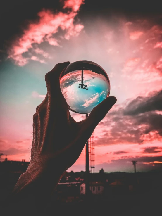 a person holding a crystal ball in their hand, a picture, by Adam Marczyński, pexels contest winner, with vibrant sky, instagram post 4k, person made out of glass, portrait photo