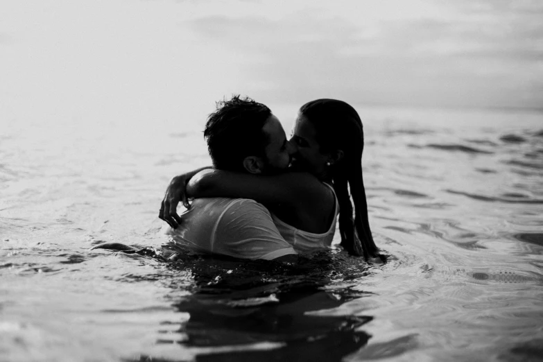 a man and a woman kissing in the water, a black and white photo, unsplash, photo of the middle of the ocean, ariel perez, holding each other, 15081959 21121991 01012000 4k