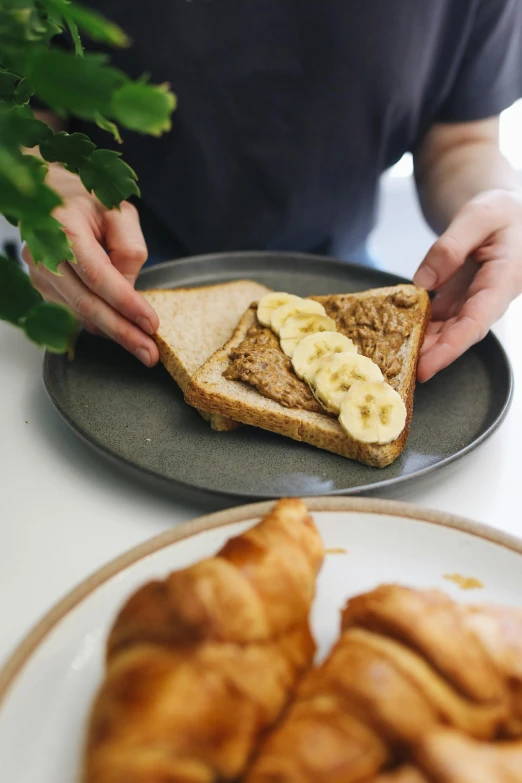 a person sitting at a table with a plate of food, inspired by Richmond Barthé, unsplash, sliced banana, brood spreading, manuka, frontal shot