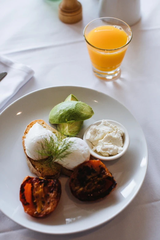 a white plate topped with food next to a glass of orange juice, renaissance, caulfield, breakfast, 5k, avocado