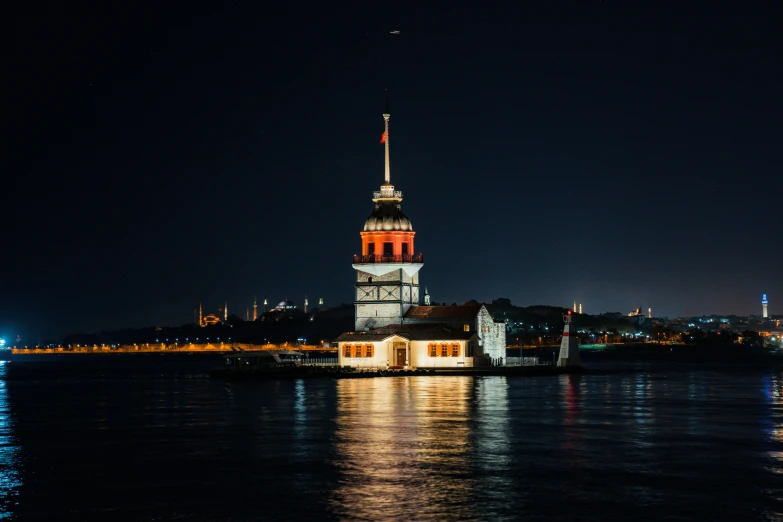 a large clock tower sitting on top of a body of water, by Yasar Vurdem, pexels contest winner, hurufiyya, set in observatory at night, ottoman empire era, portrait mode photo, red building