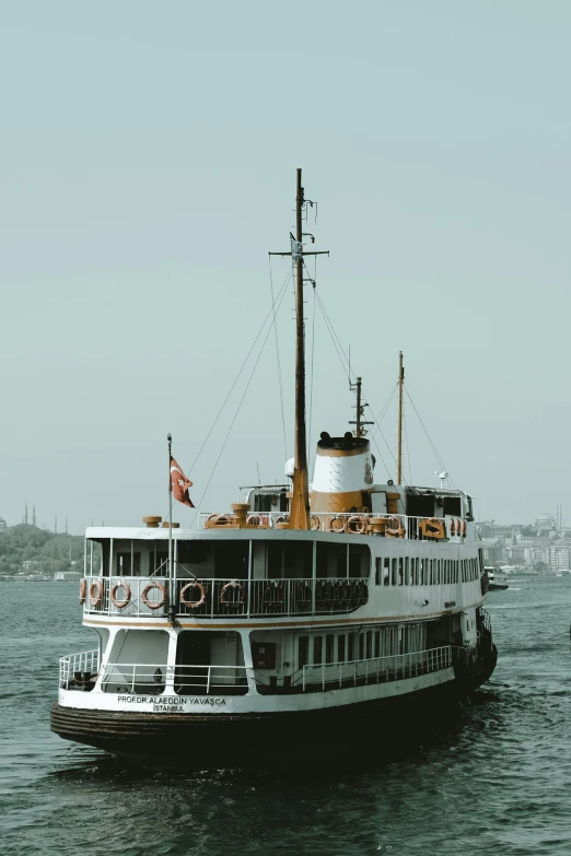 a large boat floating on top of a body of water, by Niyazi Selimoglu, pexels contest winner, art nouveau, istanbul, brown and white color scheme, steamboat willy, slide show