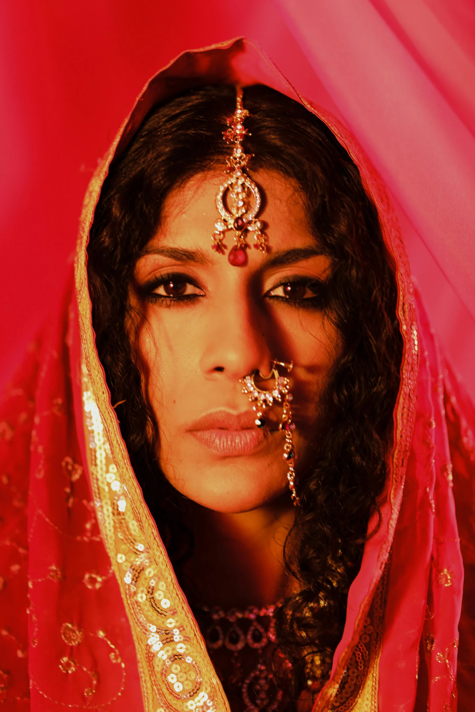 a close up of a woman wearing a veil, an album cover, inspired by Osman Hamdi Bey, dada, freida pinto, with red haze, movie still, wearing ornate clothing
