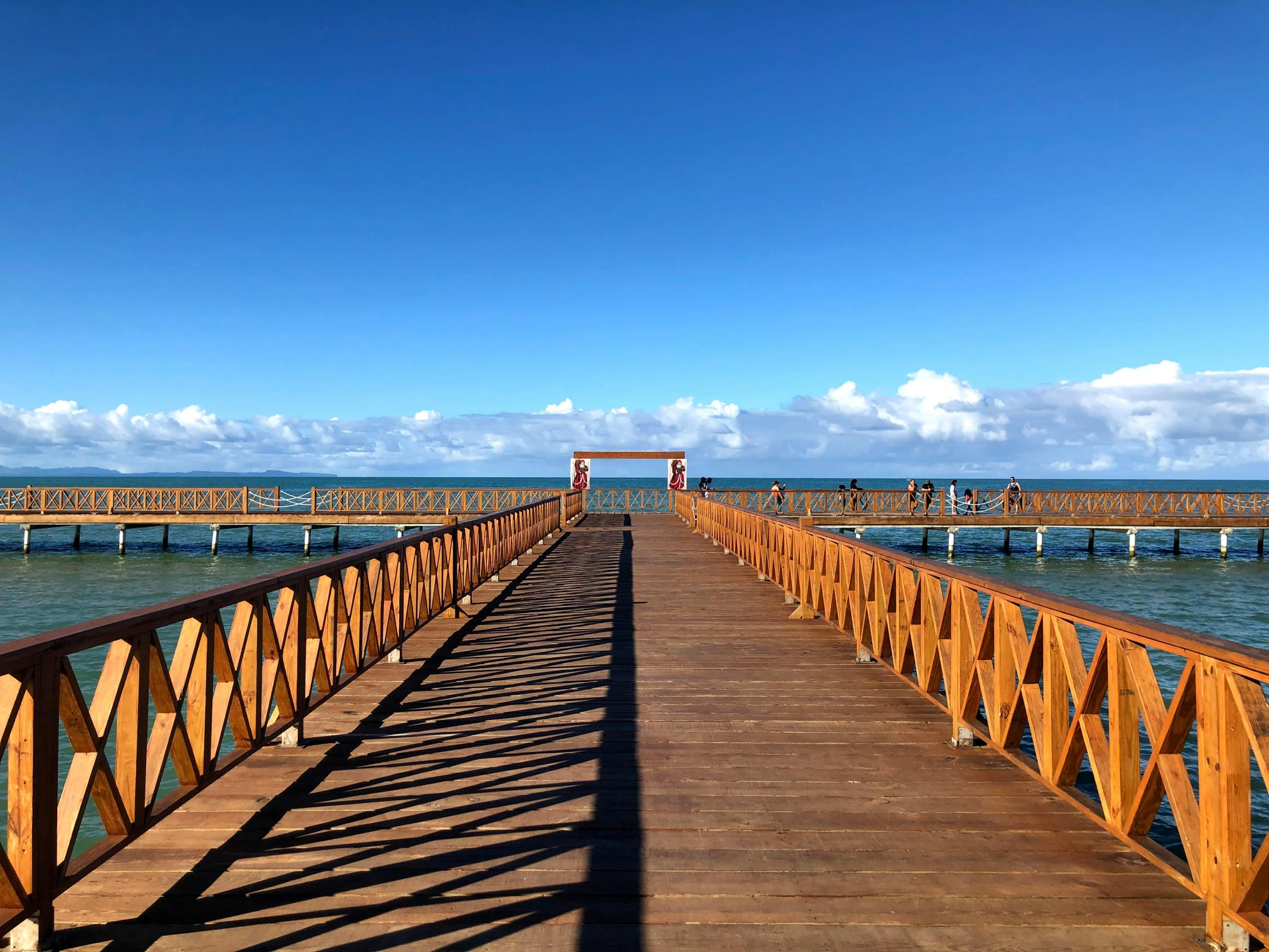 a wooden bridge over a body of water, pexels contest winner, mingei, in chuquicamata, clear blue sky, thumbnail, with walkways