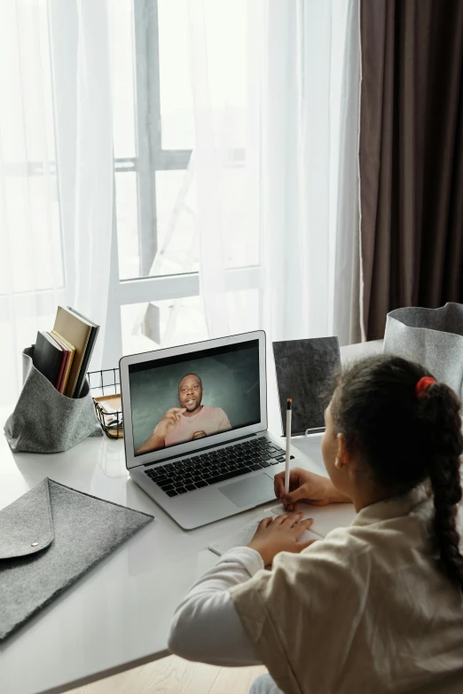 a little girl sitting in front of a laptop computer, pexels contest winner, renaissance, photo of a black woman, webcam, classroom, facing away from the camera