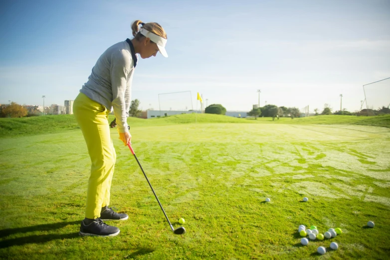 a woman taking a swing at a golf ball, by Matthias Stom, pexels contest winner, square, avatar image, high quality upload, standing