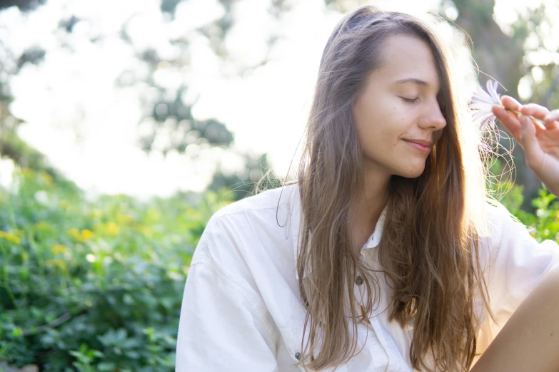 a beautiful young woman sitting on top of a lush green field, trending on unsplash, close - up profile face, wearing a linen shirt, brightly-lit, portrait sophie mudd