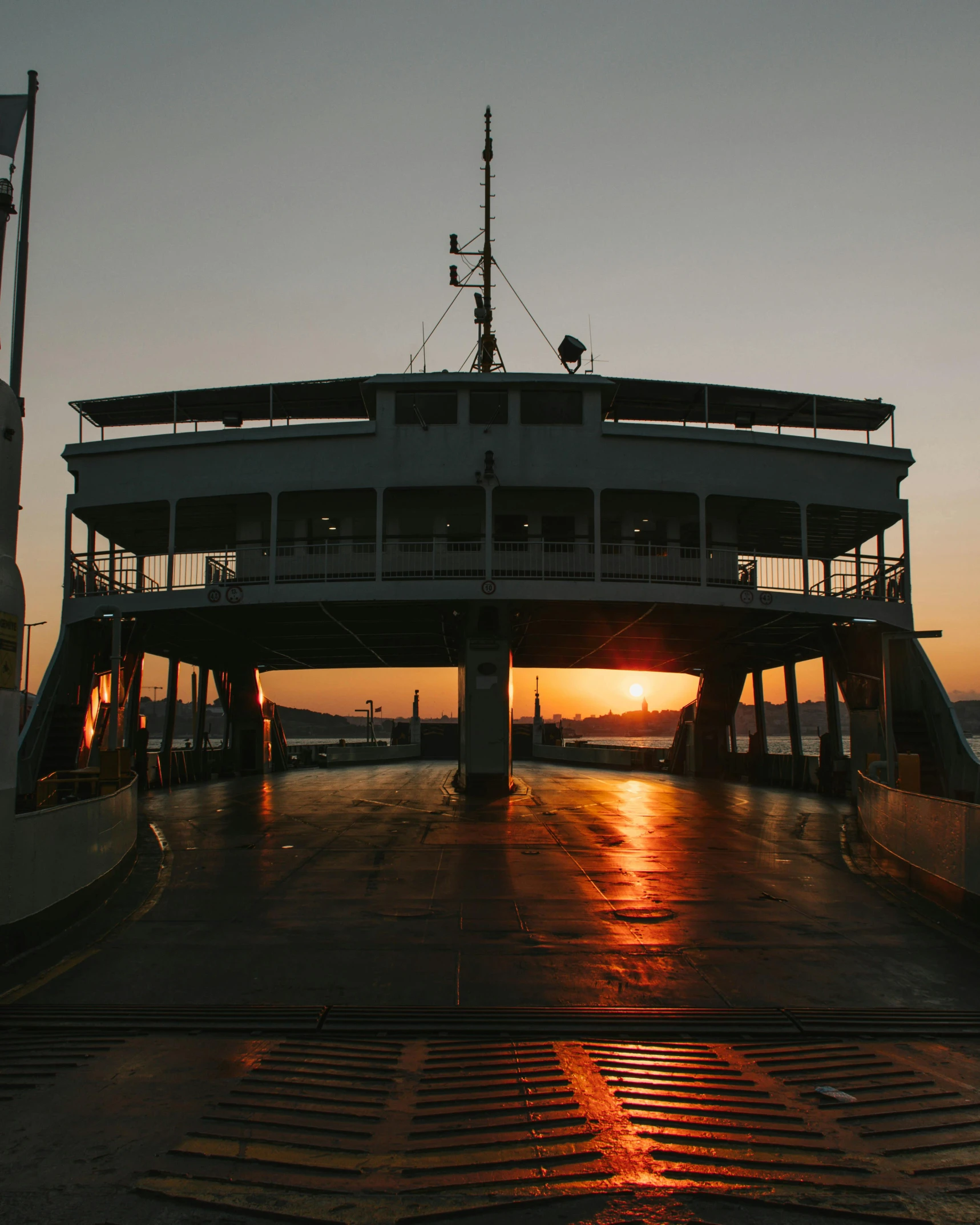 a large boat sitting on top of a body of water, an album cover, pexels contest winner, romanticism, interior of staten island ferry, sun down, boat dock, lgbtq