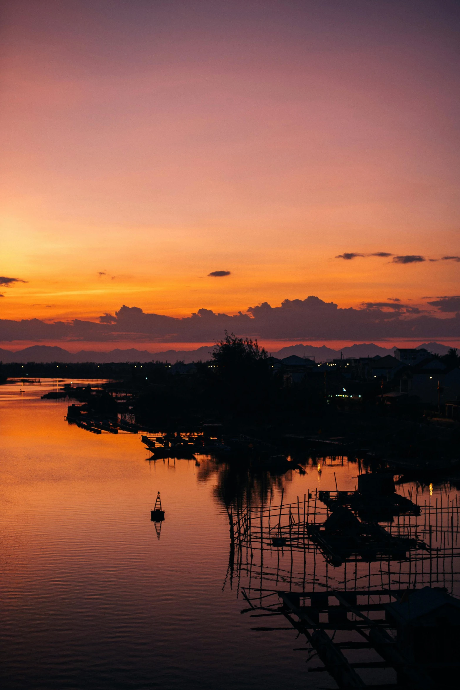 the sun is setting over a body of water, by Sven Erixson, pexels contest winner, vietnam, far view, waterways, low quality photo